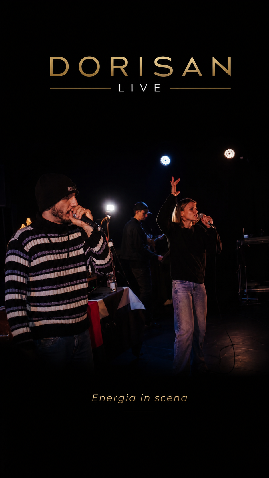 Due performer posano schiena contro schiena sul palco durante una serata dal vivo.